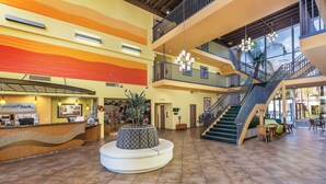 A spacious lobby with a reception desk, a central seating area, and a staircase leading to upper floors. - WorldMark Palm Springs (Palm Springs)