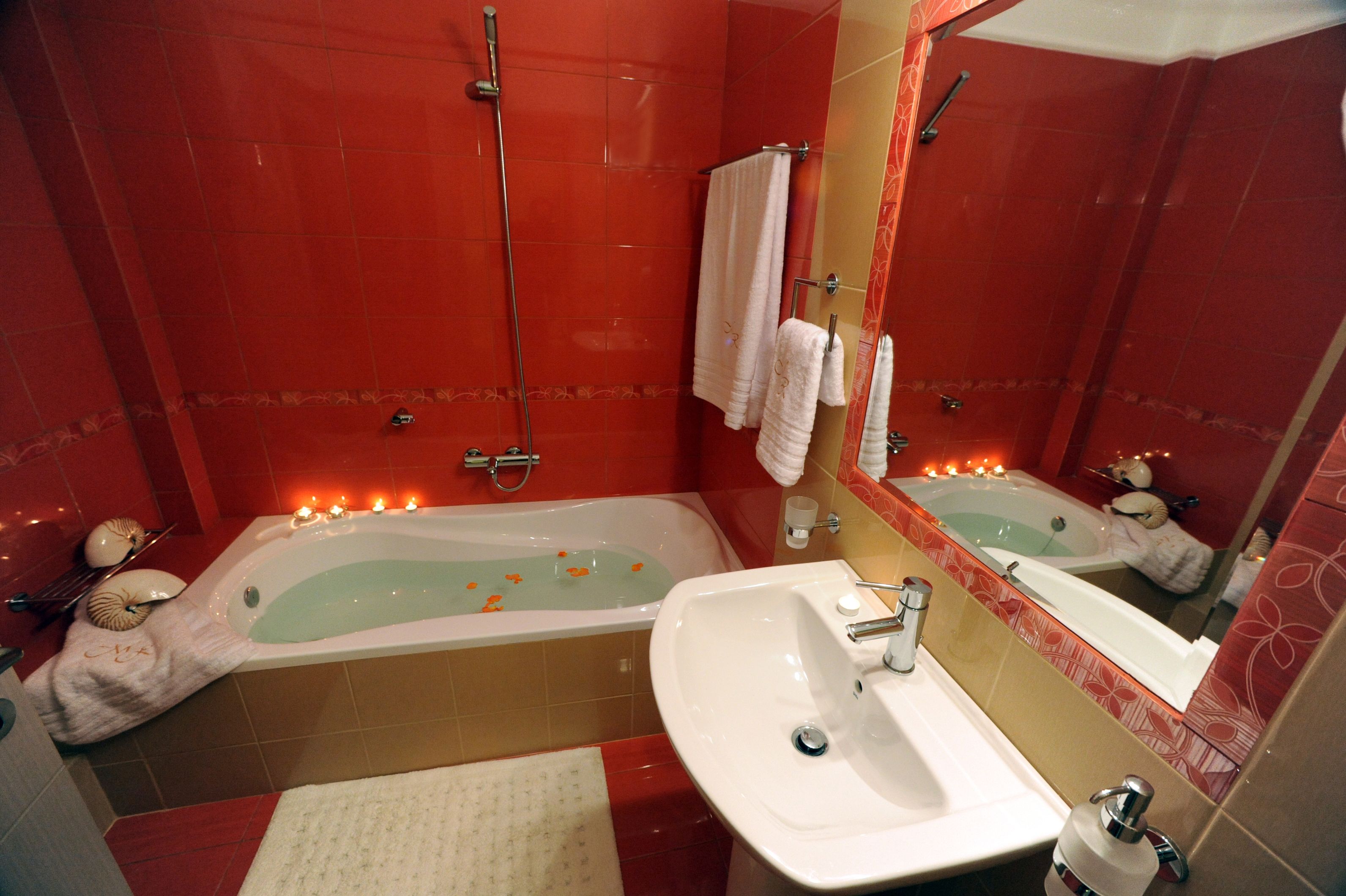 A bathroom with a bathtub, a sink, and a mirror.