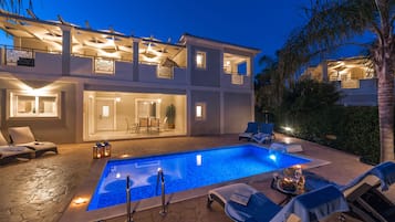 Una piscina al aire libre, sombrillas, tumbonas