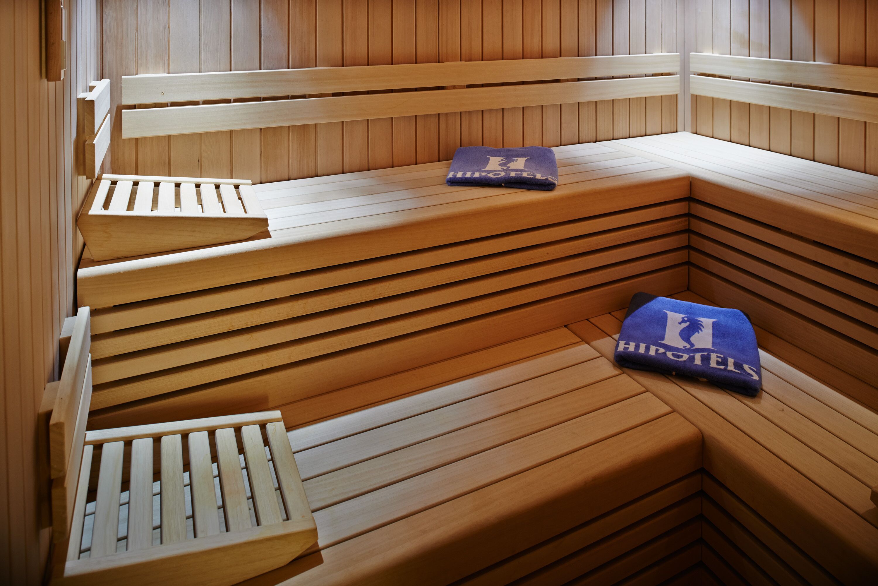 Banco de sauna de madera con una toalla que dice 'HIPOTELS'.