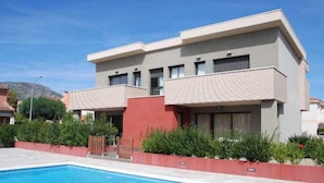 A modern two-story building with a swimming pool in front. - Casas Adosadas Romani (Mont-roig del Camp)
