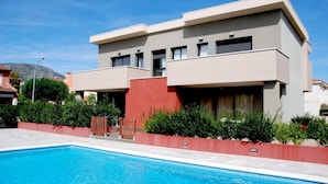 A modern two-story building with a swimming pool in front. - Casas Adosadas Romani (Mont-roig del Camp)