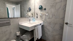 A bathroom with a white sink, mirror, towel rack, and a toilet. - Canary Garden Club (San Bartolomé de Tirajana)