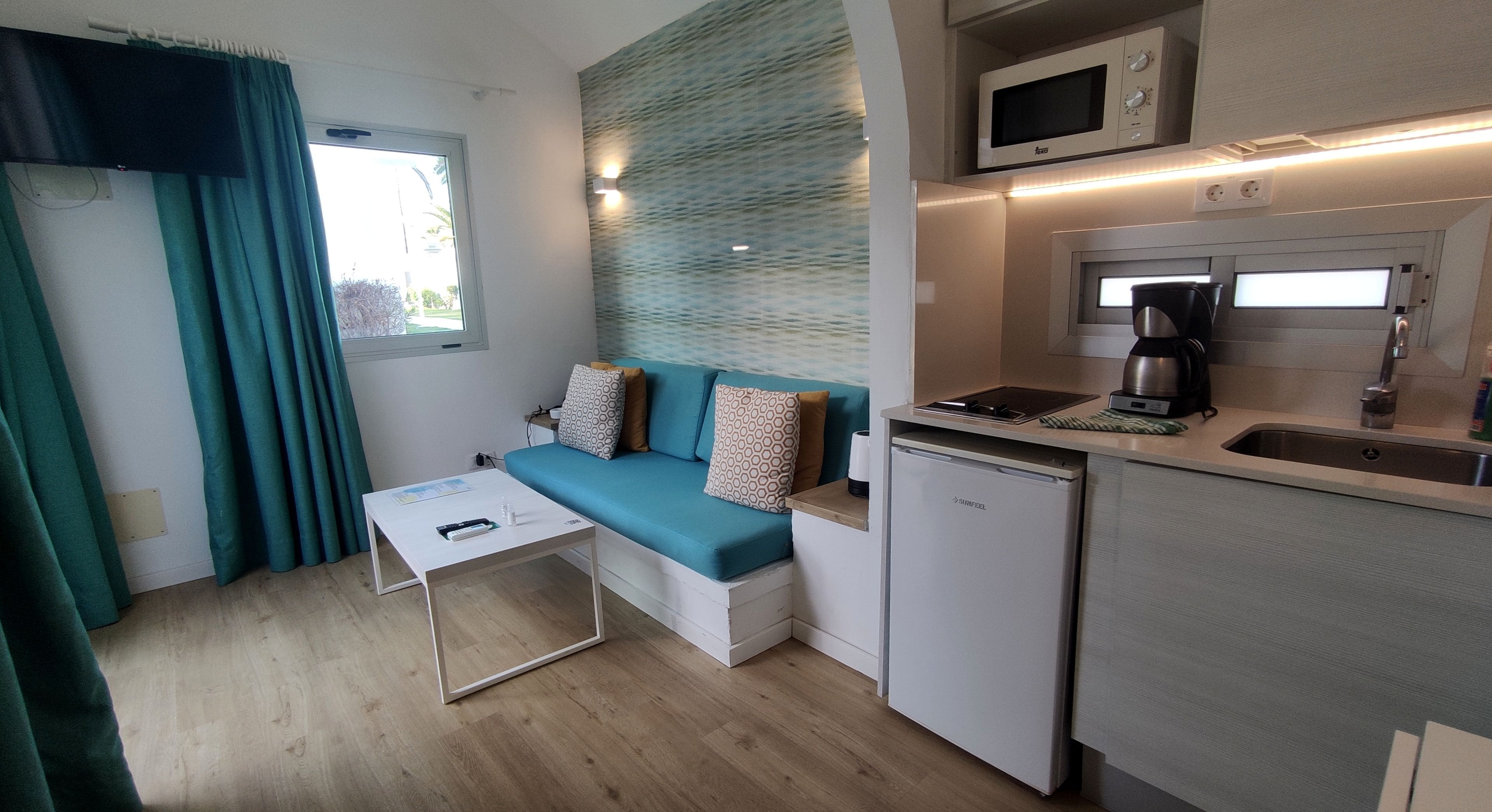 A compact kitchenette with a built-in microwave, coffee maker, and dishwasher.