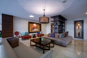 A modern living room with a sofa, armchairs, a coffee table, and a bookshelf. - Palmeras Beach Hotel (Alanya)