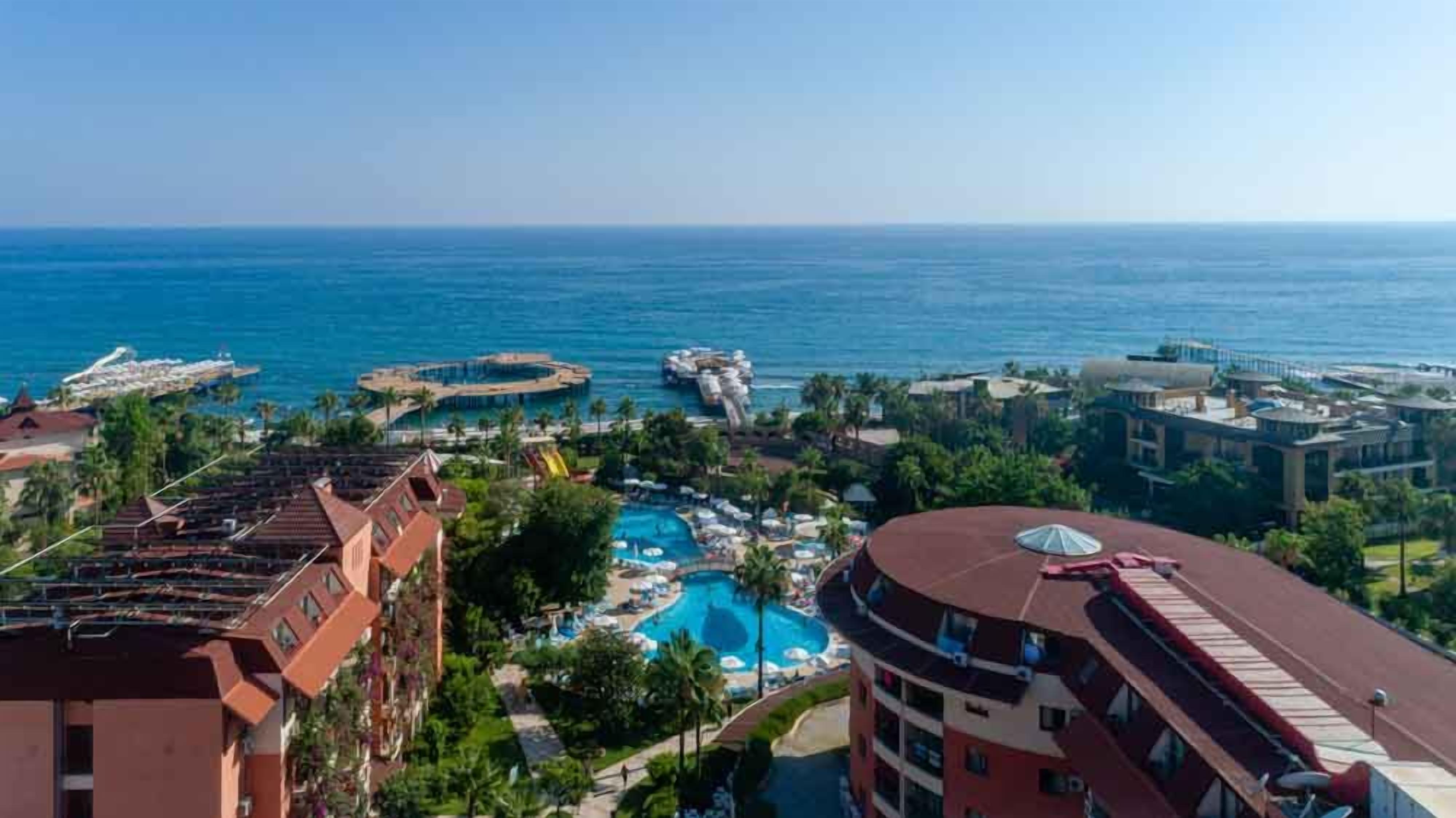 Ein Resort mit mehreren Schwimmbecken, einem Strandbereich und Blick auf den Ozean.