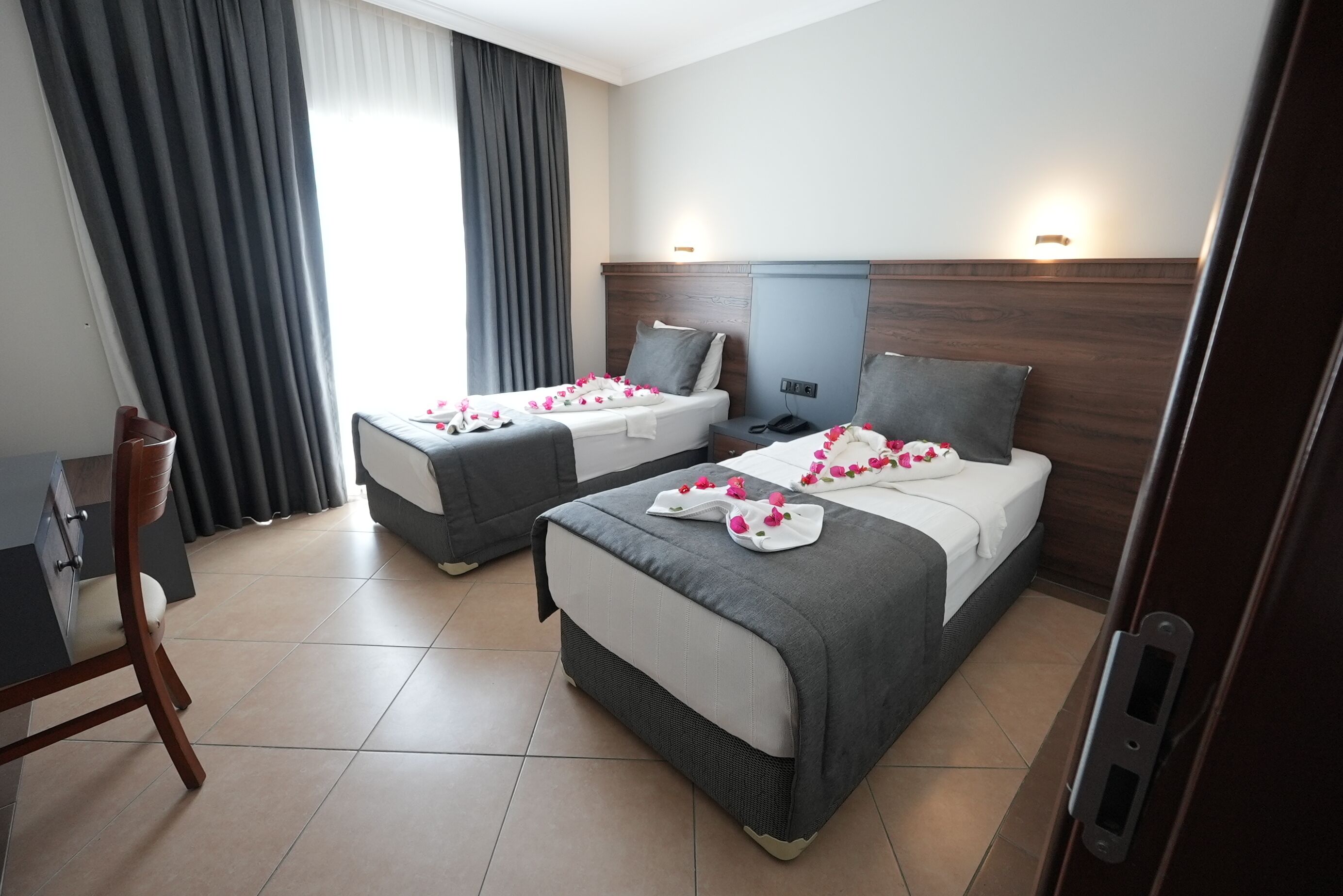 Une chambre d’hôtel avec deux lits, un bureau et une chaise.