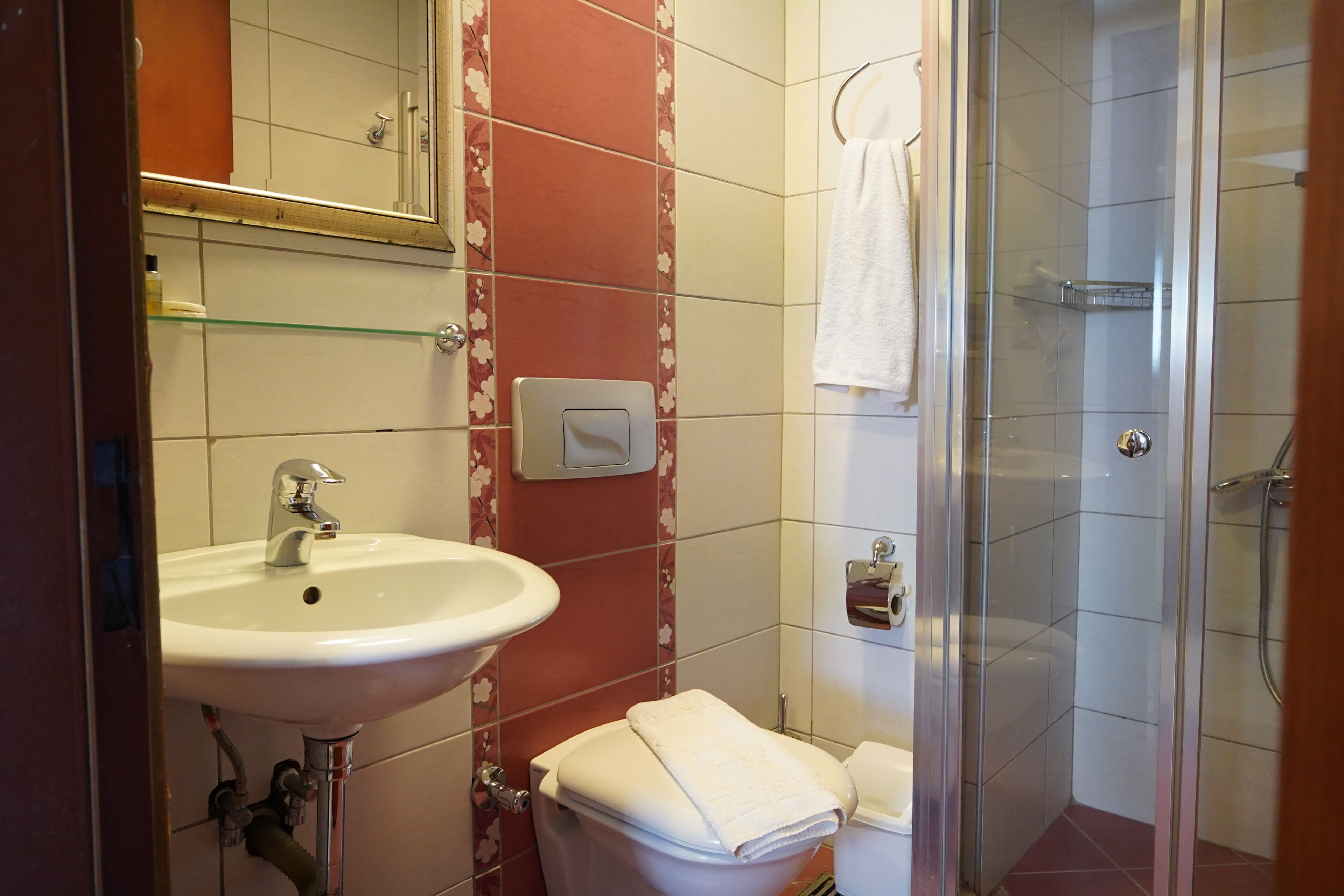 A bathroom with a sink, toilet, and shower.