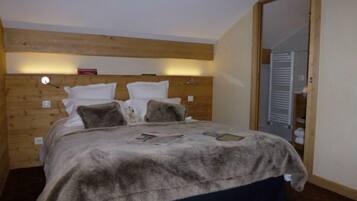 Un dormitorio con cabecera de madera, cama con manta de piel y un espejo en la esquina.