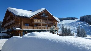 A wooden chalet-style hotel with a sign indicating it is a restaurant. It features a balcony and a view of a snowy mountain slope. - Hôtel Restaurant Les Sapins Wellness & Gourmet (Manigod)