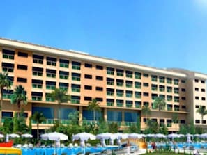 A hotel with a large pool area, multiple umbrellas, and palm trees. - Casa Fora Beach Resort (Manavgat)