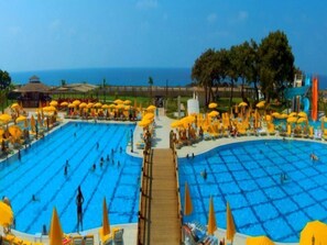 A large outdoor swimming pool with multiple lanes, surrounded by sun loungers and umbrellas. - Casa Fora Beach Resort (Manavgat)