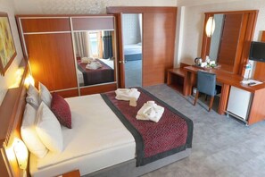 A hotel room with a bed, a desk, a mirror, and a wardrobe. - Casa Fora Beach Resort (Manavgat)