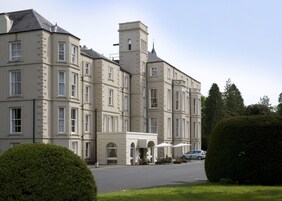 A large, multi-story building with a symmetrical facade, multiple windows, and a central tower.