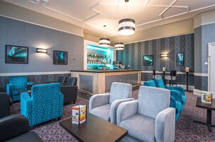 A lobby with seating areas, a bar, and a reception desk.