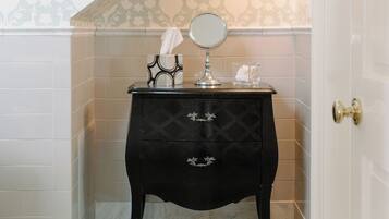 A bathroom with a black vanity, a mirror, and a tissue box.