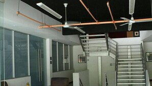 Um interior moderno com uma escadaria, área de refeições e uma janela grande.