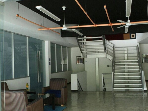 Un interior moderno con una escalera, una zona de comedor y un amplio ventanal.