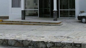 Uma casa de dois andares com telhado vermelho, janelas grandes e alicerce de pedra.