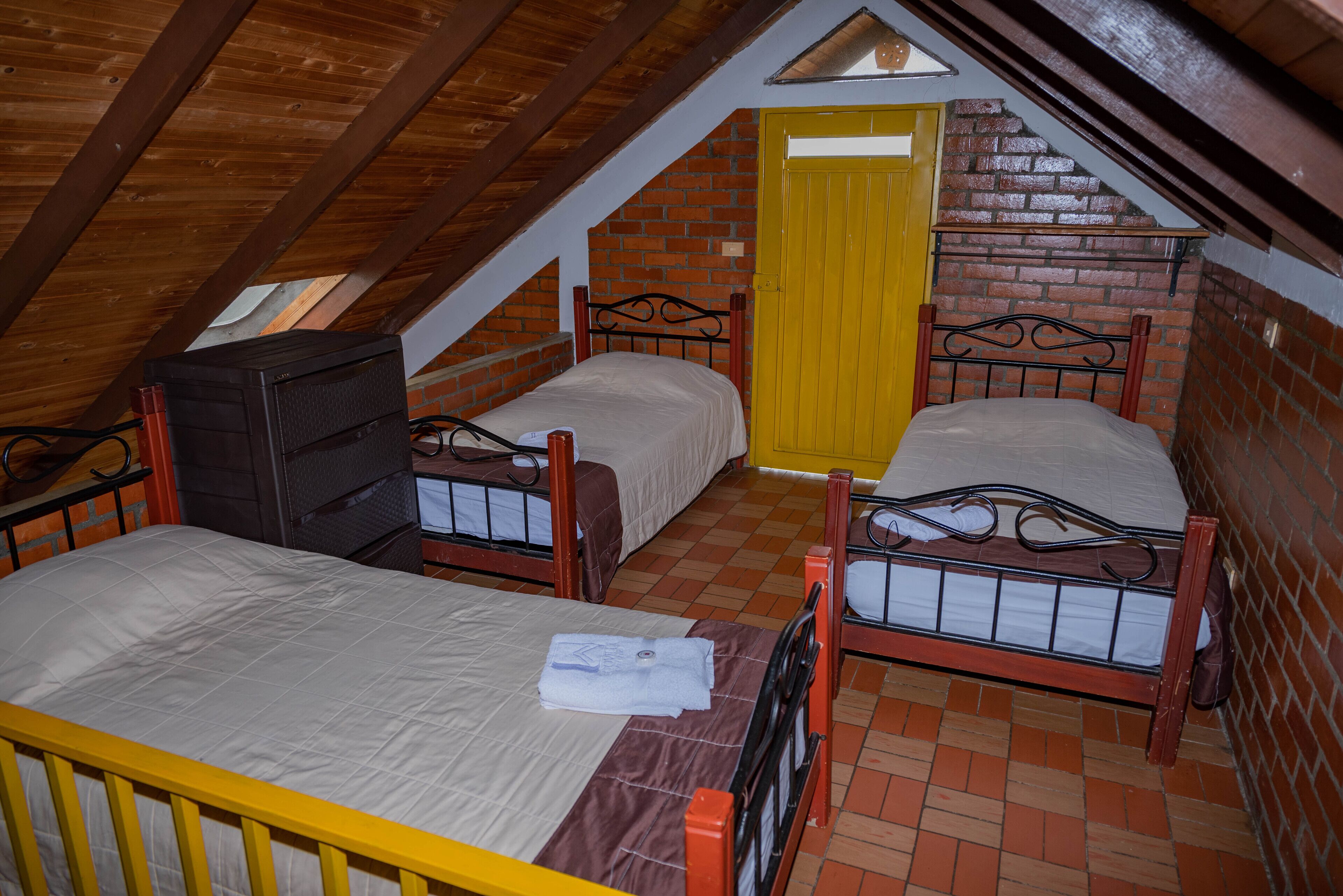 Ein Schlafsaalzimmer mit zwei Betten, einem Schreibtisch und einem Fenster.