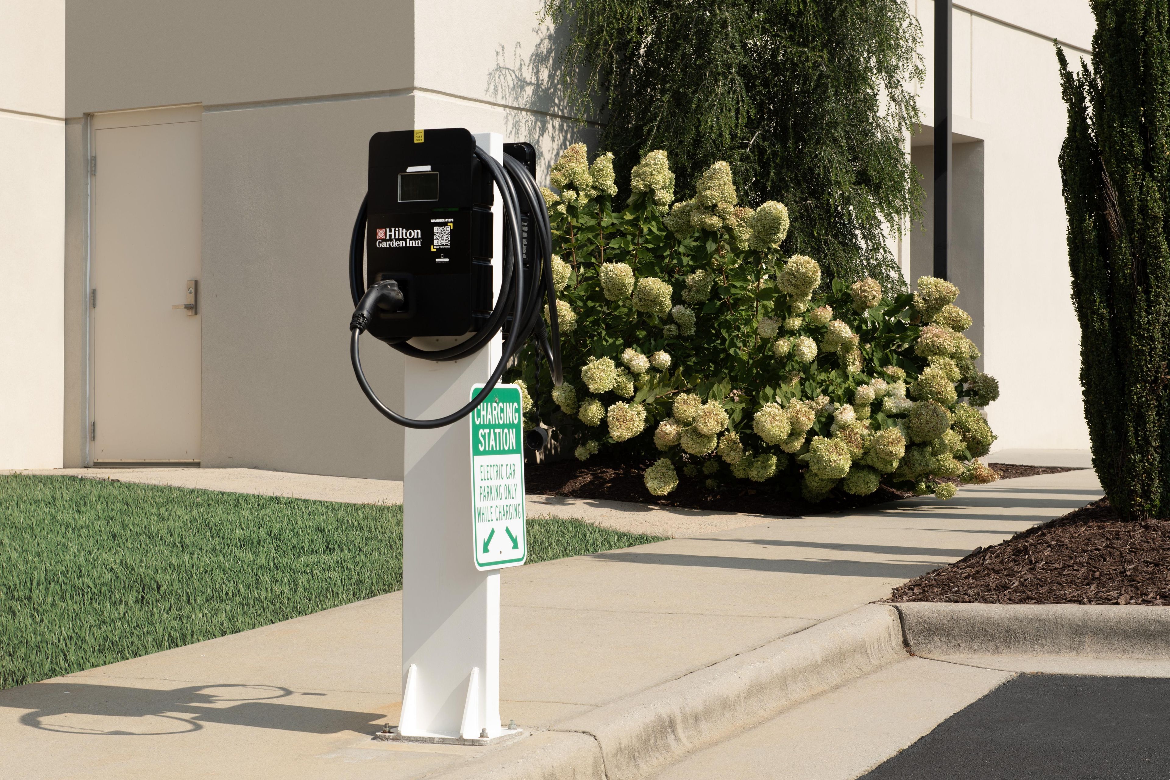 Estación de carga para coches eléctricos con un cartel que indica que es solo para estacionamiento de vehículos eléctricos durante la carga.