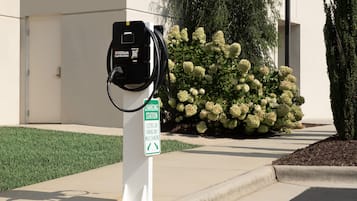 Estación de carga para coches eléctricos con un cartel que indica que es solo para estacionamiento de vehículos eléctricos durante la carga.