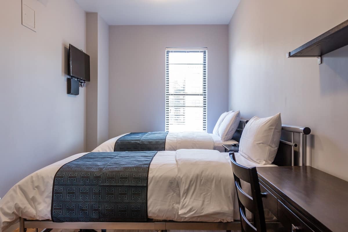 Standaard kamer (Quad Ensuite) | 2 slaapkamers, een kluis op de kamer, een bureau, een laptopwerkplek