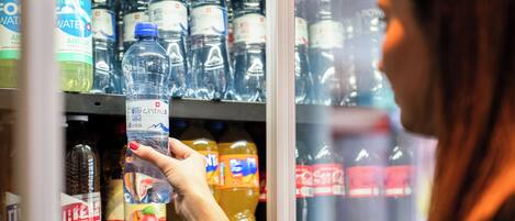 Una persona triant aigua embotellada d'un expositor refrigerat.