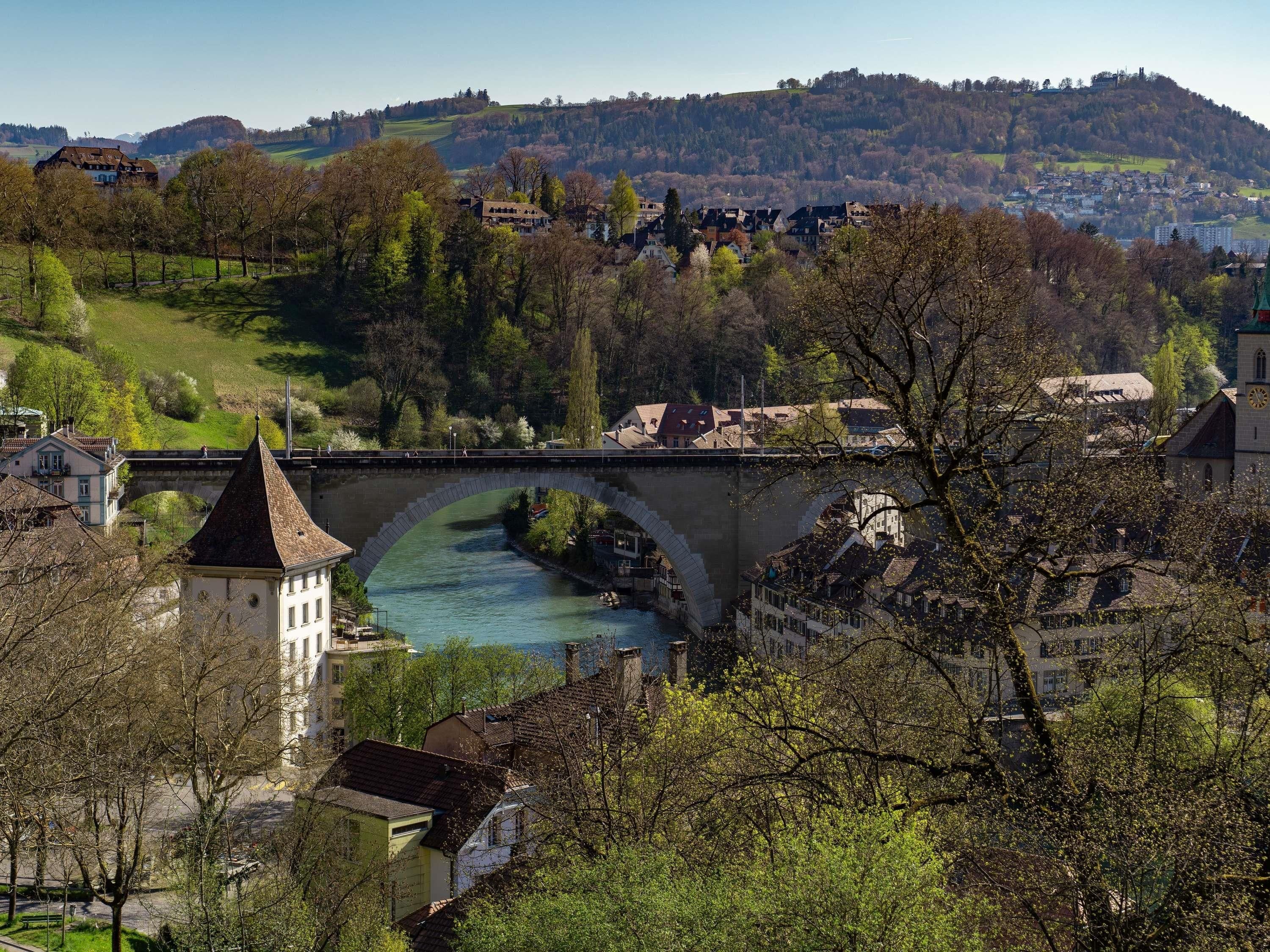 A river flowing under a stone bridge with buildings on either side.
