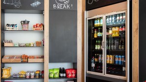 A snack and beverage display area with various packaged snacks and drinks. - ibis budget Bern Expo (Bern)