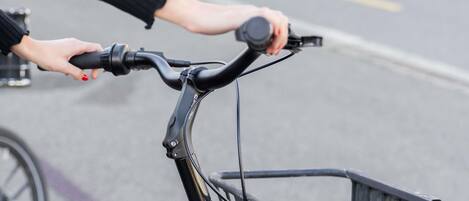 A close-up of a bicycle handlebar with a basket attached.