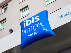 Um sinal azul com a inscrição 'ibis budget hotels'.