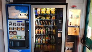 Un distributeur automatique, sur lequel on peut lire l’inscription « Service rapide », proposant des en-cas, des boissons et des barres chocolatées Mars.