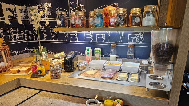 Un buffet de petit-déjeuner proposant une variété d’aliments, de condiments et une machine à café.