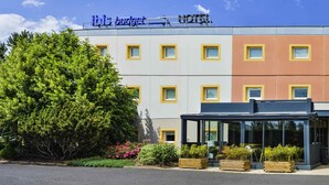 Un hôtel doté d’une façade moderne, de nombreuses fenêtres et d’une enseigne indiquant qu’il s’agit d’un hôtel économique.
