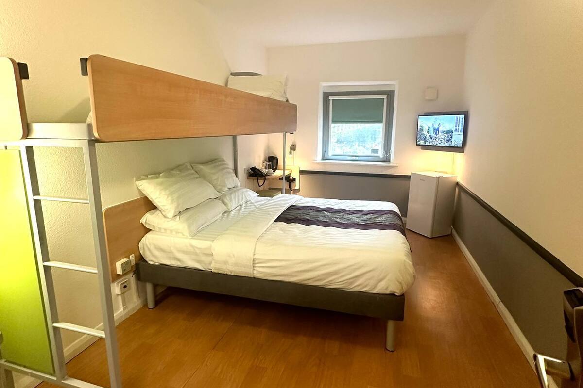 Habitación con literas, escritorio y televisor.