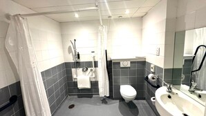 Un baño moderno con ducha, inodoro y lavamanos.