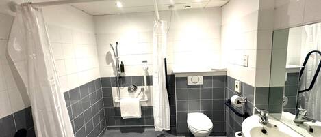 A modern bathroom with a shower, toilet, and sink.
