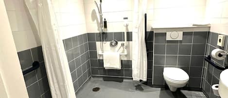A modern bathroom with a shower, toilet, and sink.