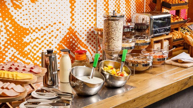 Una mesa de buffet con distintos alimentos y utensilios.