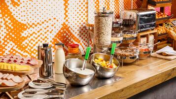 Una mesa de buffet con distintos alimentos y utensilios.