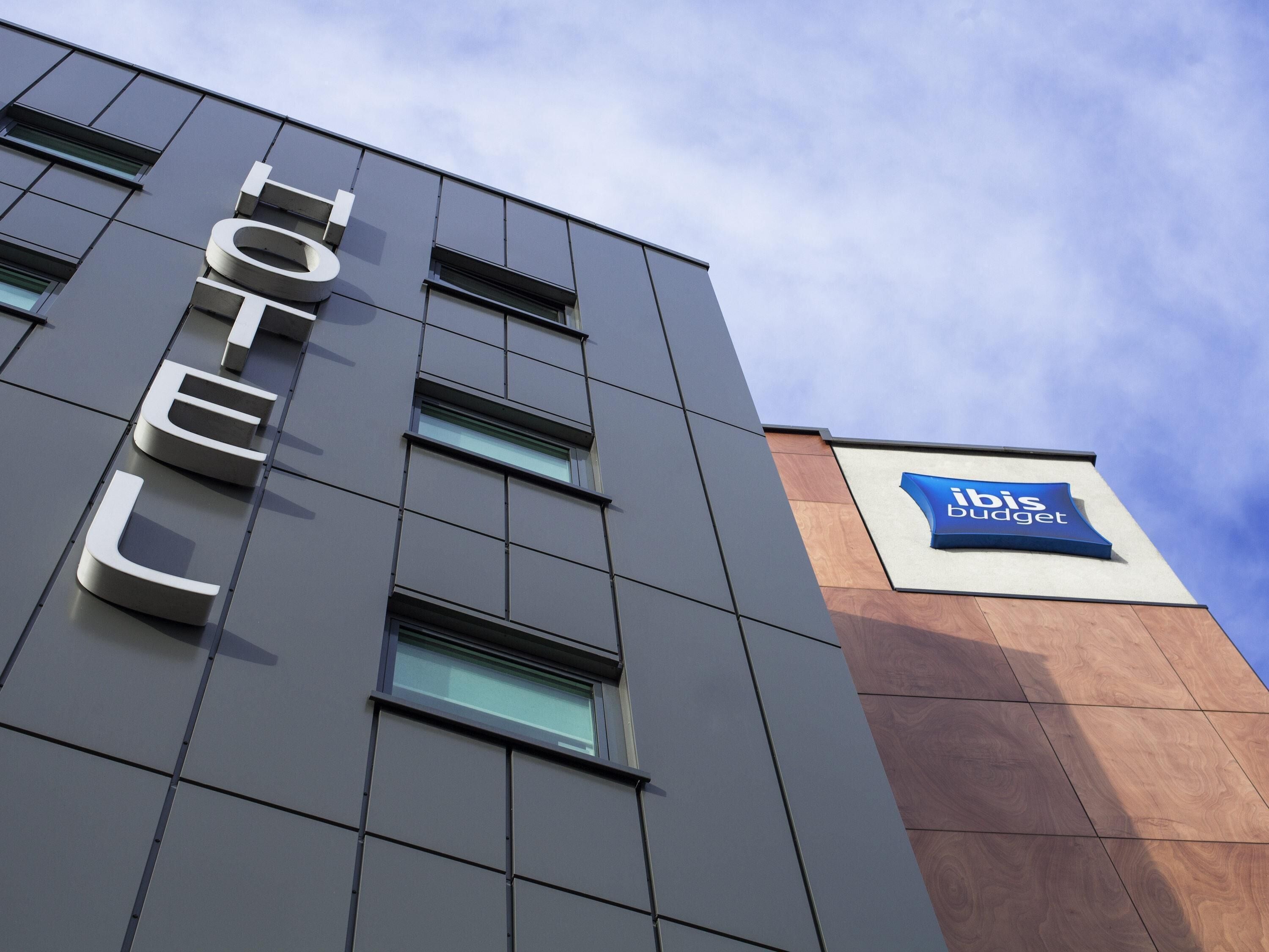 A hotel building with a prominent 'HOTEL' sign and an 'Ibis Budget' logo.