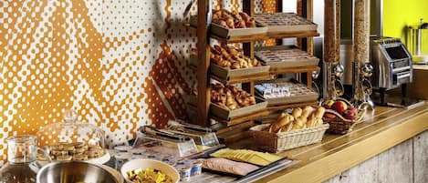 Un bufé de desayuno con diversas opciones de comida y una máquina de café.