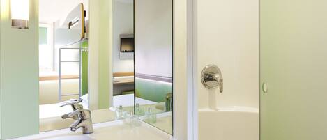 A bathroom with a white sink, a mirror, and a door.