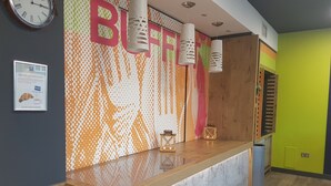 Un mostrador de recepción con una pared estampada, un reloj y un cartel.