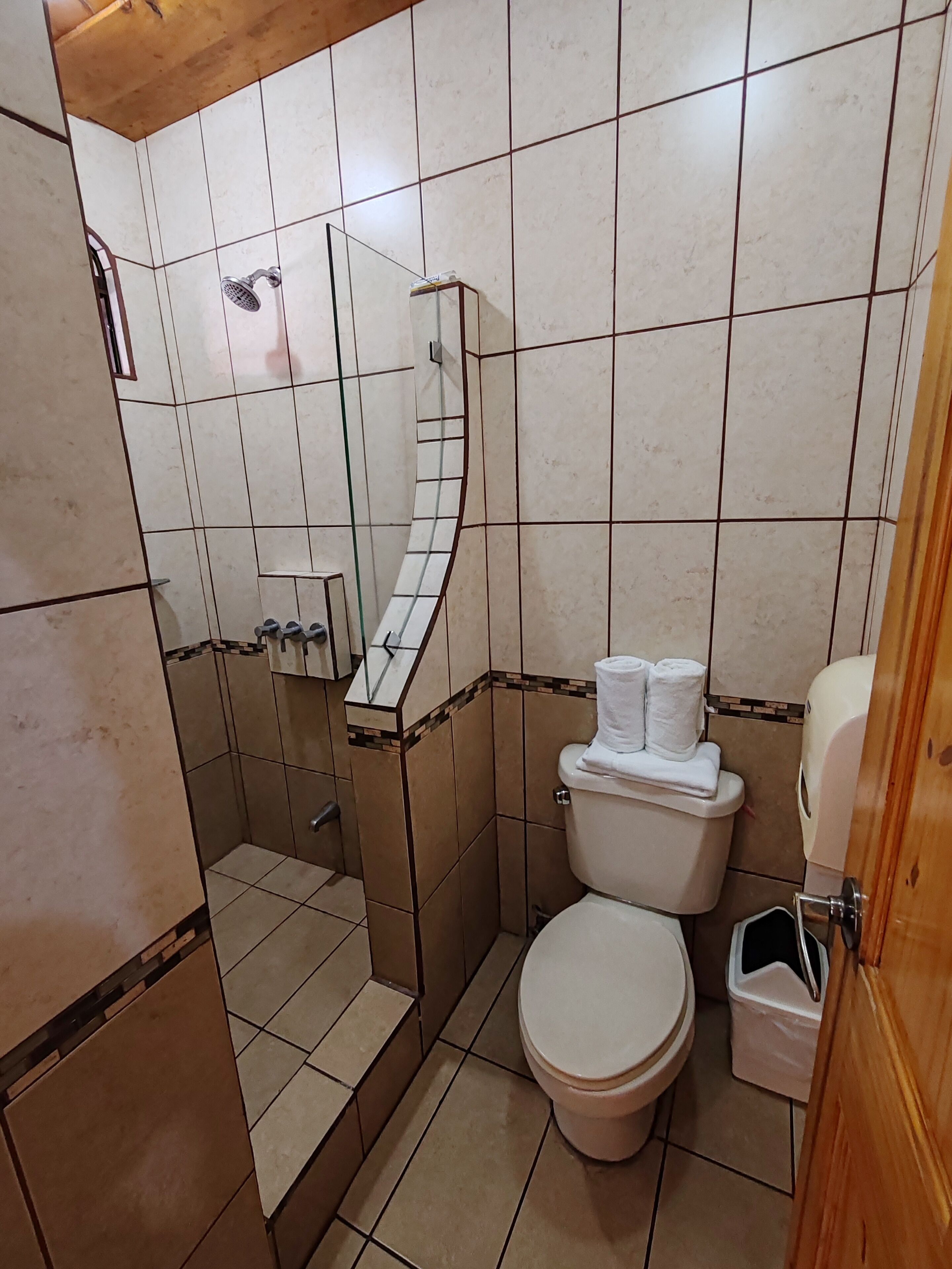 Un bagno con doccia, WC e lavandino.