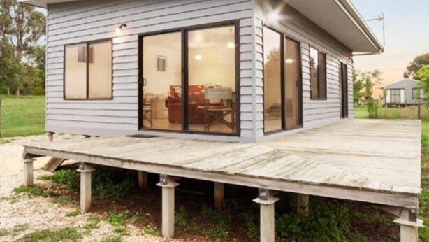 A modern single-story house with a covered patio and large sliding glass doors. - Abington Farm (Heyfield)