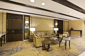 A hotel lobby with a sofa, armchairs, a coffee table, and a lamp. -  Changi Transit Hotel Terminal 3 (Singapore)