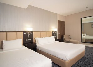 A hotel room with two beds, a nightstand, a chair, and a large mirror. - Changi Transit Hotel Terminal 3 (Singapore)