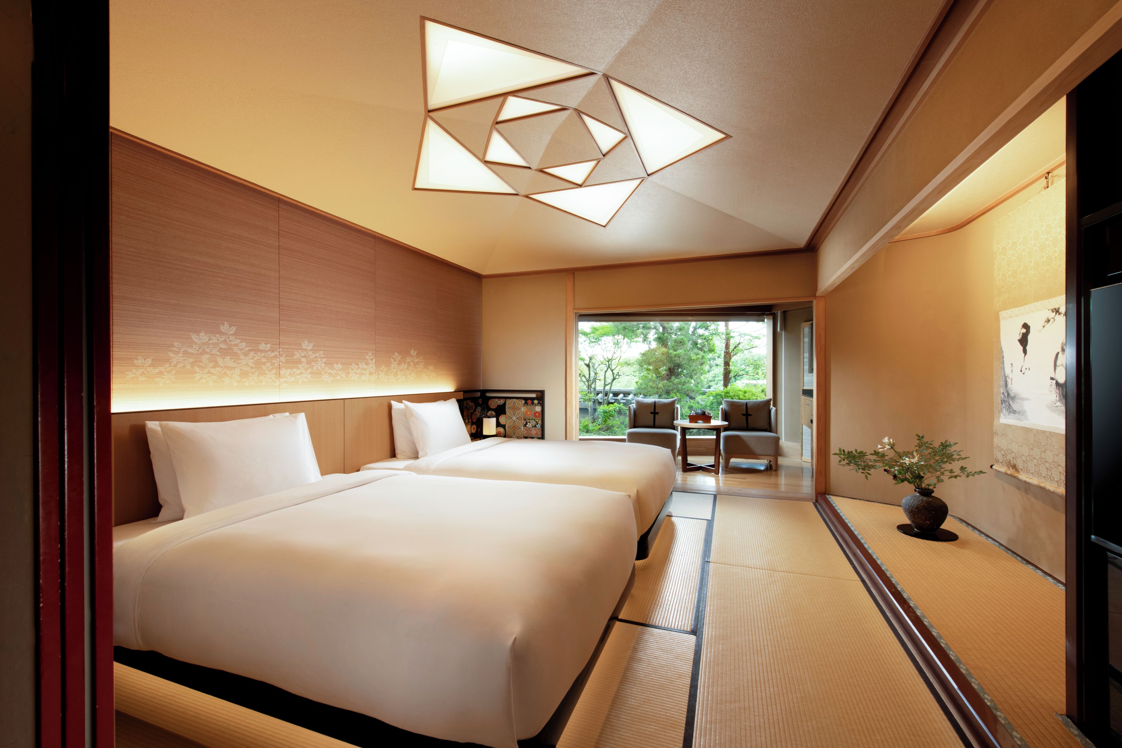 A hotel room with two beds, a large window, and a view of the outdoors.